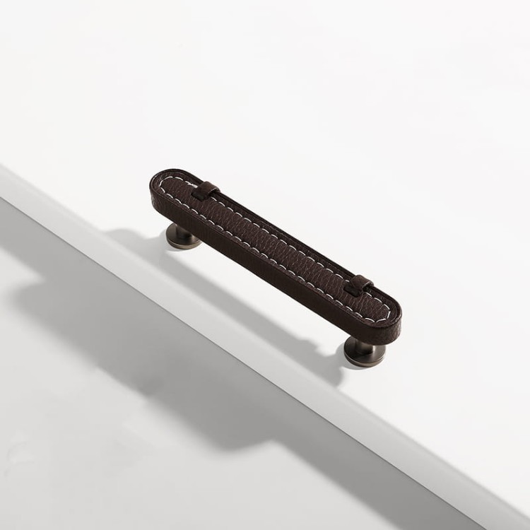 Möbelgriff Museo – dekorativer Ledergriff mit runden und quadratischen Knöpfen in Schwarz, Braun, Grau und Weiß. Als Knopf sowie in 96 und 128 mm erhältlich. Ideal für Küchen- und Badmöbel – egriffe.at