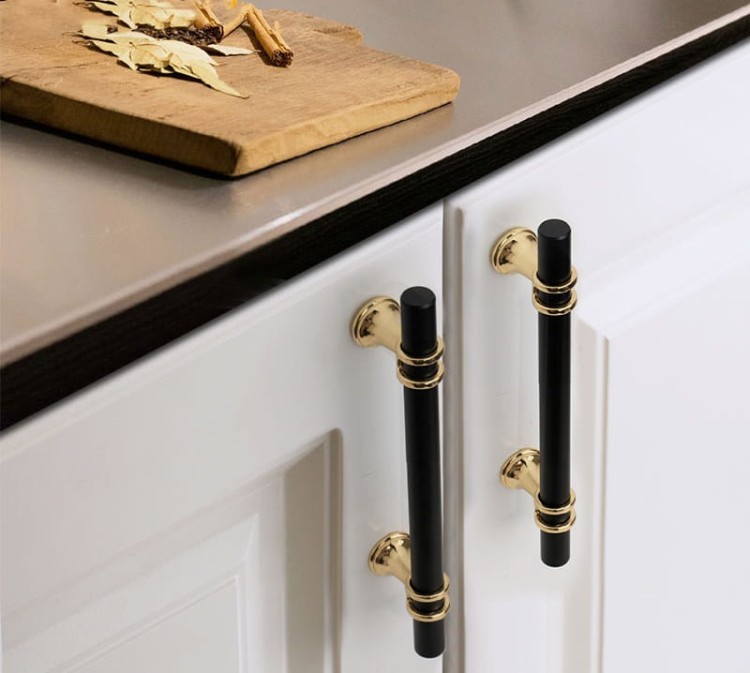 Möbelgriff Pina – eleganter T-Bar-Griff mit dekorativen Stützen in Schwarz-Gold oder Schwarz-Chrom. Als Knopf sowie in 96, 128 und 160 mm erhältlich. Ideal für Schränke, Kommoden und Schiebetüren – egriffe.at