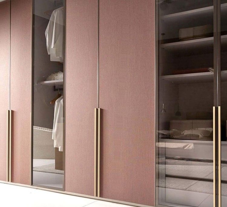 Gebürsteter goldener Jimba-Möbelgriff an hohen Fronten eines Kleiderschranks im Schlafzimmer