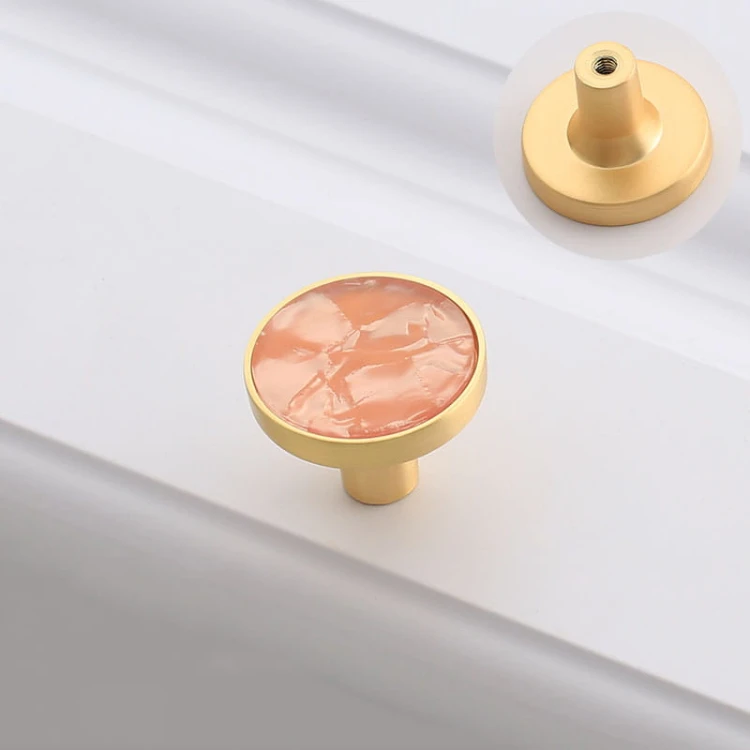 Puderrosa Möbelknopf Santa mit goldfarbener Fassung, ideal für Mädchenzimmer und Kommoden.