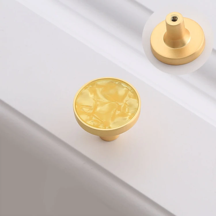 Warmer gelber Möbelknopf Santa mit fein strukturierter Einlage und goldfarbenem Metallrand.