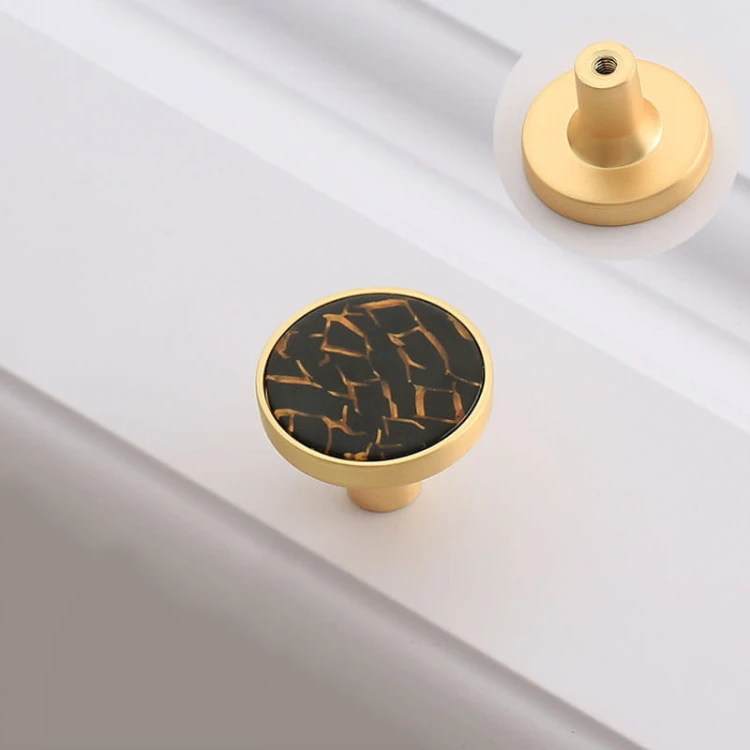 Dunkelgrauer, grafitfarbener Möbelknopf Santa für Kommoden in einer glänzenden goldfarbenen Metallfassung.