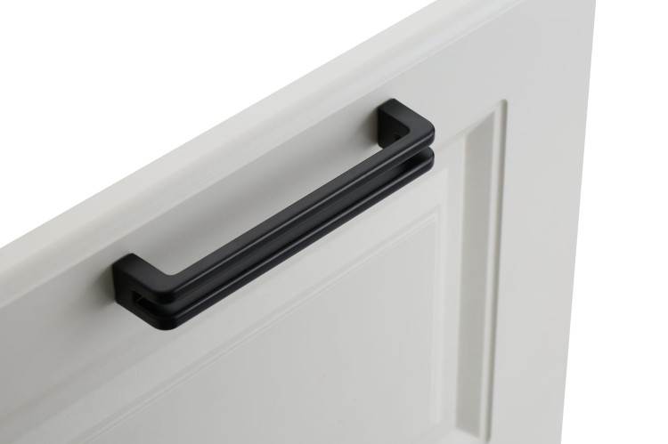 Schwarzer Möbelgriff Pino in Aufsatzform, horizontal an einer weißen Möbelfront präsentiert.