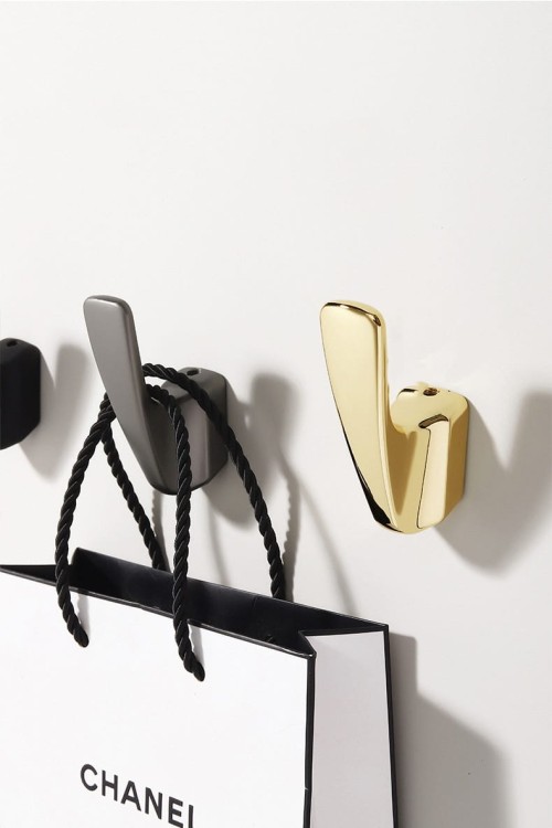 Wandhaken Alegre – moderne minimalistische Form aus robustem Material, einfache Montage. Ideal für Bad, Küche, Flur und Büro. Farben: Gold, Schwarz, gebürstetes Gold und Grau.