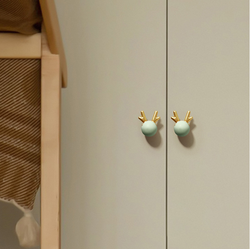 Gałka meblowa Deer – pastelowa kula z dekoracyjnym złotym porożem Dostępna w kolorach: róż, zieleń, błękit, biel Idealna do szuflad, komód i szafek w dziecięcych pokojach w bajkowym, skandynawskim stylu