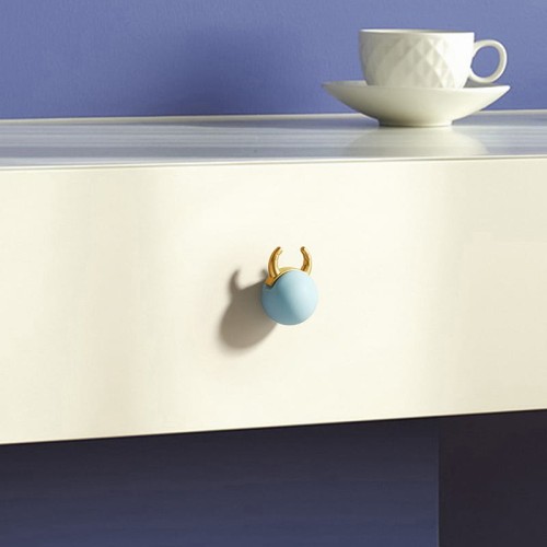 Gałka meblowa Cow w kształcie pastelowej kuli z złotymi rogami doda uroku dziecięcym meblom – idealna do szuflad, komód i szafek w pokoju malucha.