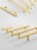 Möbelgriff Alma – schlichter zylindrischer T-Bar-Griff in Gold, Champagnergold oder Schwarz, passend für moderne und klassische Interieurs. Viele Größen für Kommoden, Schränke, Garderoben und Badmöbel.