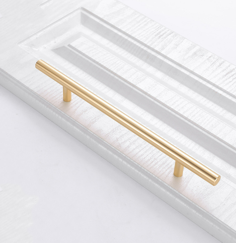 Möbelgriff Alma – schlichter zylindrischer T-Bar-Griff in Gold, Champagnergold oder Schwarz, passend für moderne und klassische Interieurs. Viele Größen für Kommoden, Schränke, Garderoben und Badmöbel.