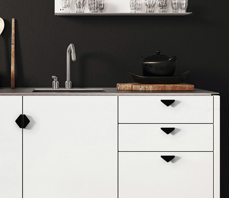 Möbelgriff Isa – asymmetrischer Dreiecksgriff mit markanter geometrischer Form. In gebürstetem Gold oder Schwarz, ideal für Küchenfronten, Kommoden, Vitrinen und Schränke in modernen und glamourösen Interieurs.