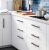Möbelgriff Alto – Perlgrau mit eleganten goldenen Details, pulverbeschichtetes Metall im modernen minimalistischen Stil. Ideal für Küchen- und Badschränke, Kommoden und Garderobe. Als T-Bar sowie in 128 und 192 mm erhältlich.