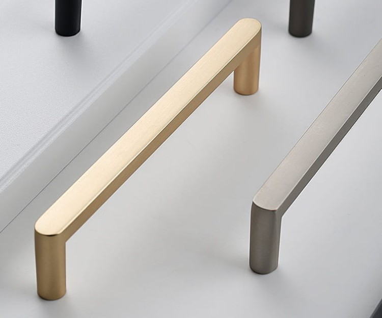 Möbelgriff Vega – moderner minimalistischer Griff in Schwarz, gebürstetem Gold, gebürstetem Nickel und Perlgrau. Größen 128–256 mm, ideal für Küche, Kommoden, Schränke, Garderobe und Bad.